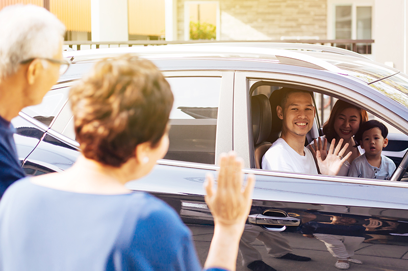 Family waving while driving